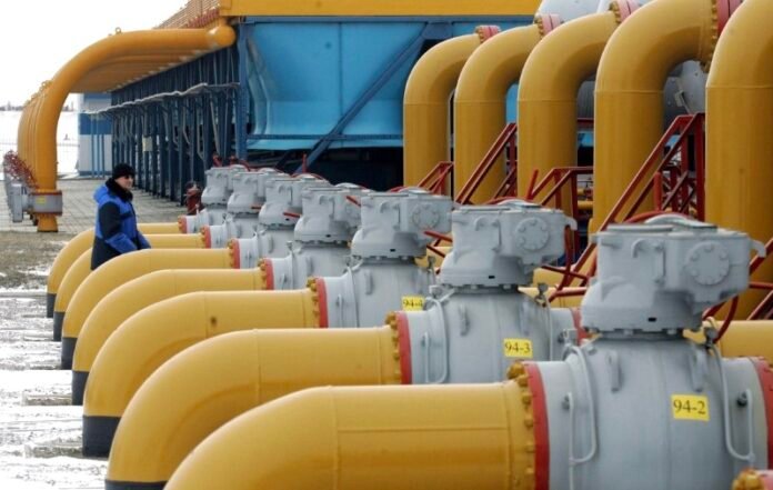 A gas worker walks between pipes in a gas compressor and distribution station near Kursk