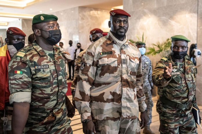 Guinean coup leader Col. Mamady Doumbouya, center, leaves a meeting with high-level representatives of the Economic Community of West African States in Conakry on September 17, 2021. AFP/GETTY IMAGES