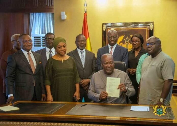 John Dramani Mahama surrounded by his staff during the signing of the bills