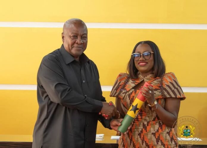 John Dramani Mahama presenting Dr. Pamela Graham with her statue of office