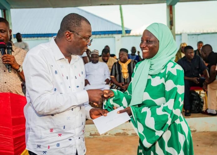 Dr Mohammed Amin Adam presenting cash support to one of the students